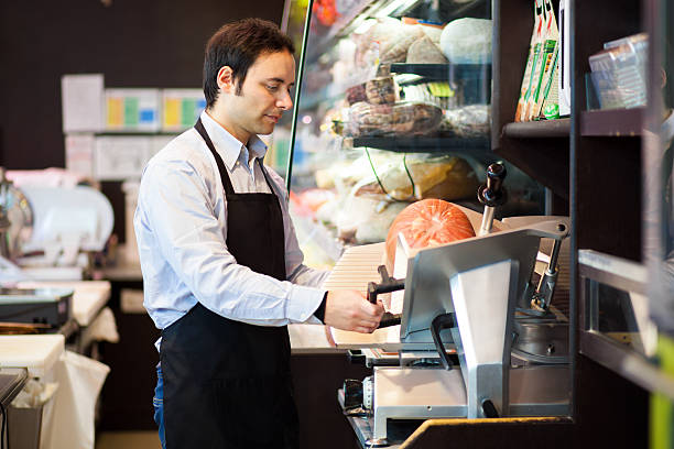 istock Shopkeeper cutting ham in a grocery store 485811230