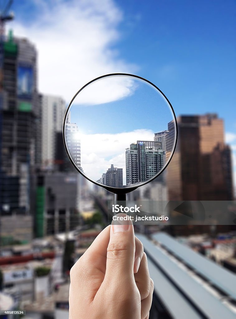 Magnifying glass and cityscape in focus, business vision Magnifying glass and cityscape in focus, business vision and view of city City Stock Photo
