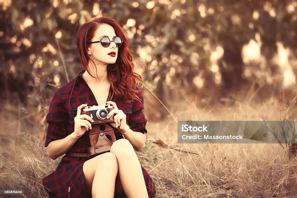 girl in plaid dress retro camera and sunglasses Beautiful girl in plaid dress retro camera and sunglasses at countryside Old-fashioned Stock Photo