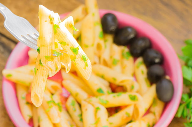 Italian pasta with tomato sauce on a fork in the sunlight