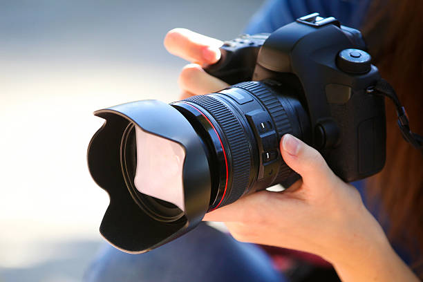 holding a full-frame-kamera. - fotograf stock-fotos und bilder