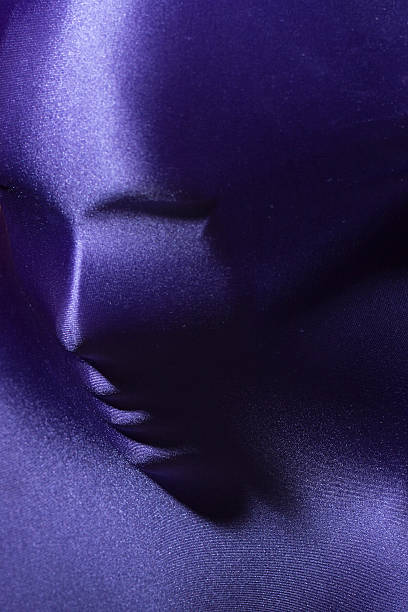 Human face under fabric Mysterious closeup portrait background of female human face under beautiful pearl purple supplex stretch fabric copyspace, vertical picture spandex stock pictures, royalty-free photos & images