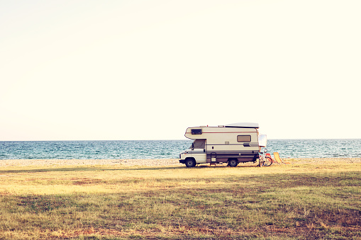 A vintage shoot with a caravan car near the Mediterranean sea in a beautiful summer day. Copy space also.