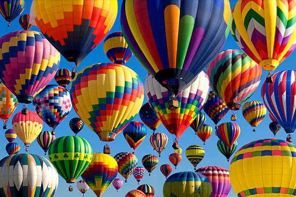 Hot Air Ballooning Composit of the mass ascension launch of over 100 colorful hot air balloons at the New Jersey Ballooning Festival in Whitehouse Station, New Jersey as a early morning race ballooning festival stock pictures, royalty-free photos & images