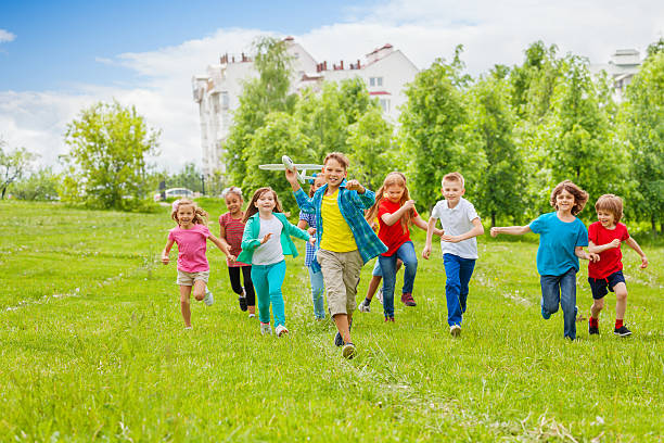 istock Boy holds big white airplane toy and kids behind 485830236