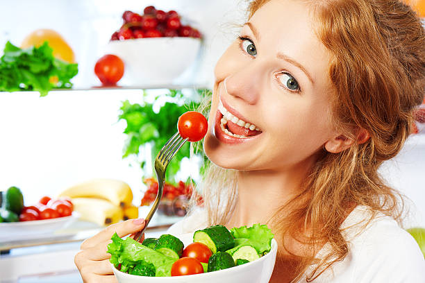 istock woman eats healthy food vegetable vegetarian salad about refrige 485836026