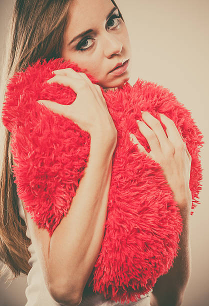 istock Sad unhappy woman holding red heart pillow 485837222