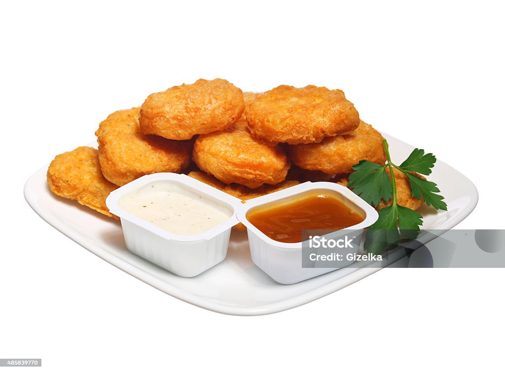 Chicken nuggets in plate with two dressings isolated Chicken nuggets in plate with two dressings isolated on white Chicken Nugget Stock Photo