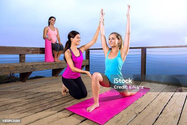 Yoga Teacher Instructor Guru Assists Beginner Student Exercise Outdoors Stock Photo - Download Image Now