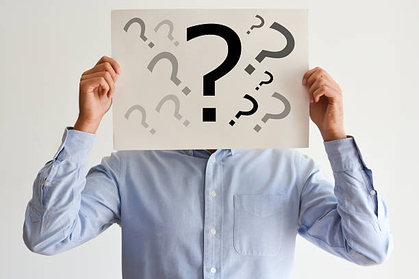 Employee dilemma with question marks on blank paper stock photo