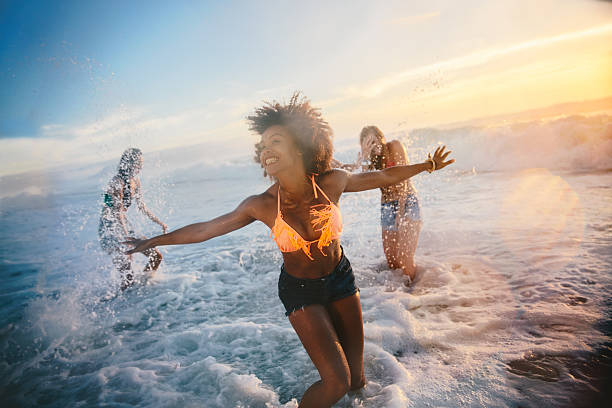 Group of friends at the beach Group of friends at the beach african american beach stock pictures, royalty-free photos & images