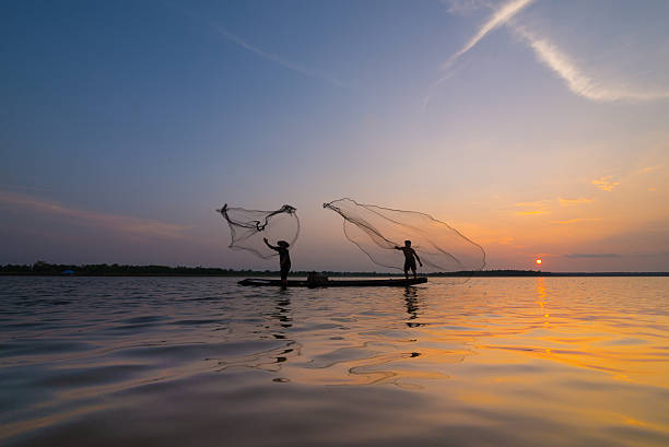 istock Silhouette of a fisherman throwing his net with sunset. 485849986