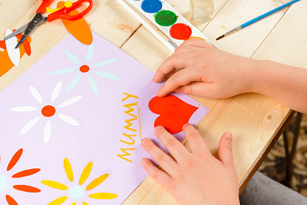 istock Child glues paper heart 485850421