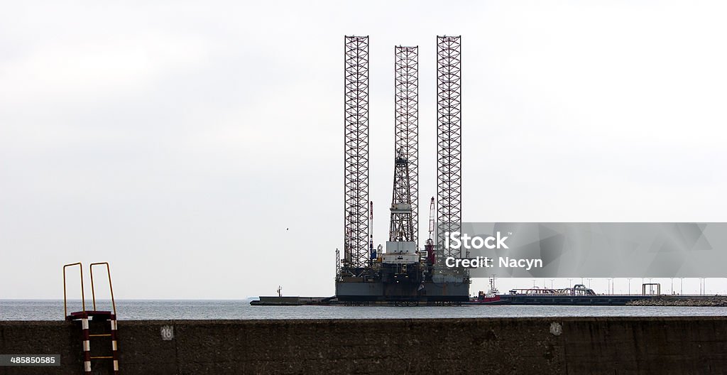 Oil Jack Up Ladder Oil platform anchored at the quay. Commercial Dock Stock Photo