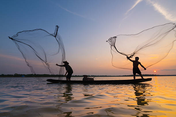istock Silhouette of a fisherman throwing his net with sunset. 485850728