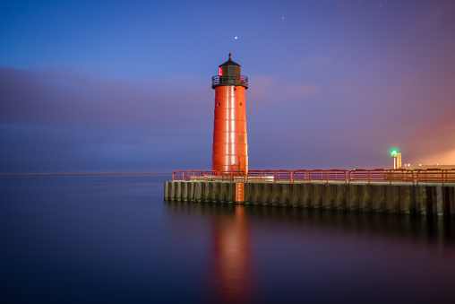 Red lighthouse at the end of a pier on Lake Michigan in Milwaukee, WI taken before the sun rise.