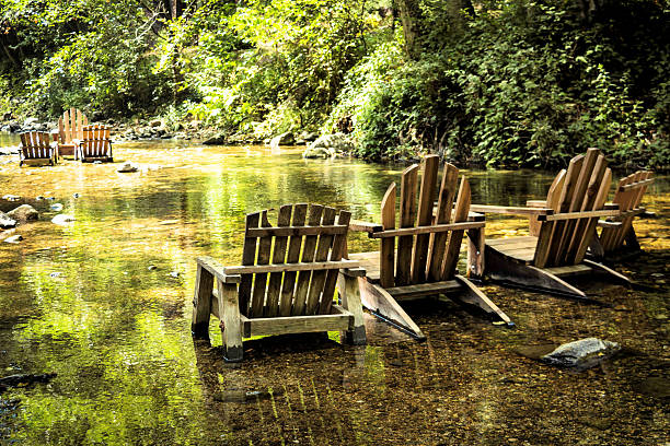 Adirondack chairs ready for lounging in the river iwth reflection and serenity