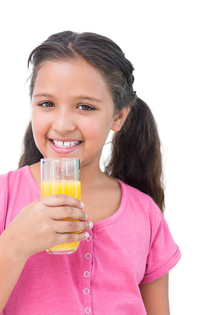 istock Happy little girl drinking orange juice 485851041