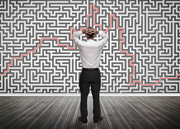 istock Confused businessman looking at a maze 485851327