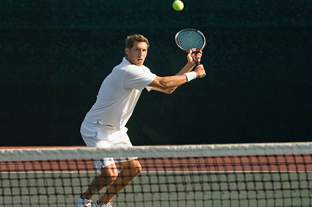 Tennis Player Swinging at Ball Tennis Player Swinging at Ball backhand stroke stock pictures, royalty-free photos & images