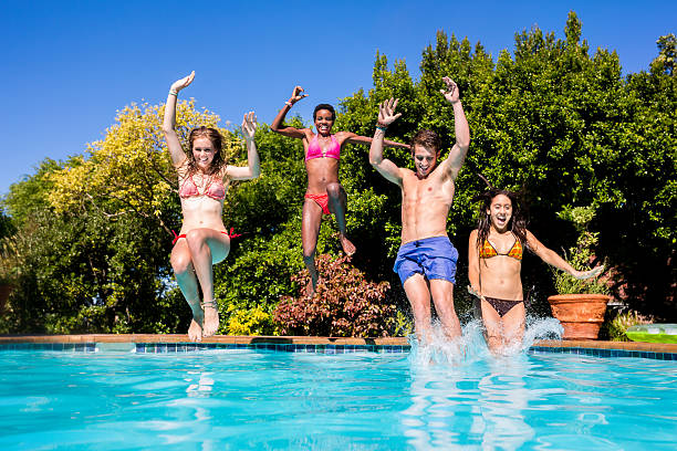 istock Happy friends jumping into a pool 485853639