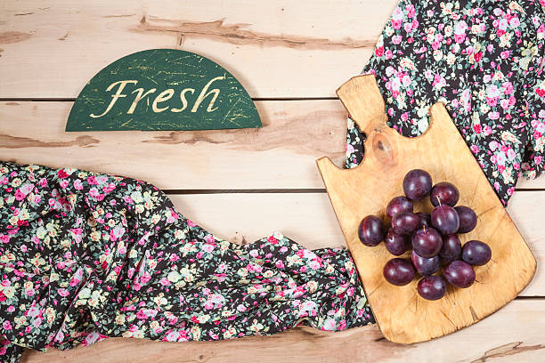 Ripe plums on the wooden background