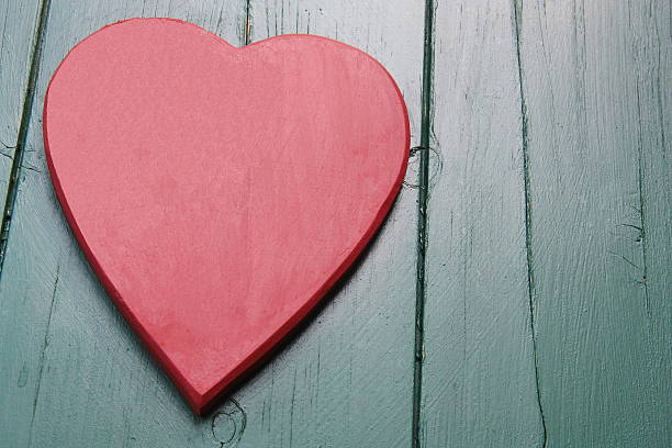 istock Red Heart on a green wooden background 485857314