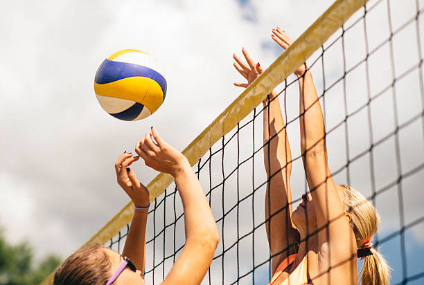 voleibol de playa doble en la red - pelota de vóleibol fotografías e imágenes de stock