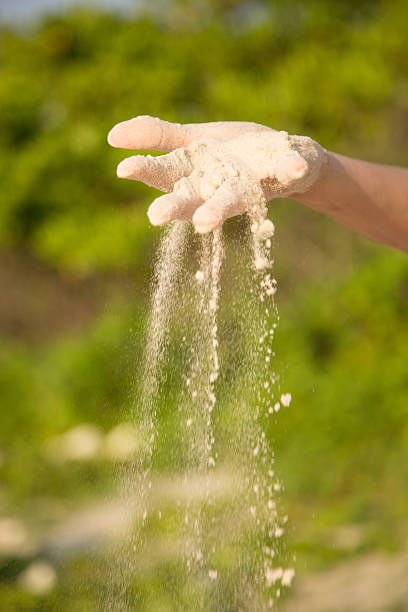 istock Hand, with falling sand outdoor, green plant background 485863870