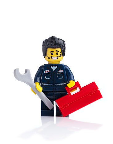 London, United Kingdom- April 17, 2014: Lego mini figure Mechanic on white background. From the collectible Mini figure Series 6 The lego figure is a small plastic toy made by a Danish toy manufacturer the Lego Group.