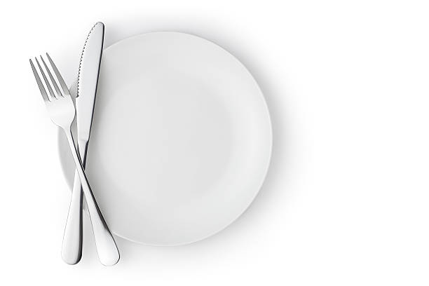 Empty plate with fork and knife Fork and knife on a empty plate, Isolated on white background. empty plate stock pictures, royalty-free photos & images