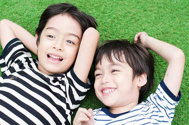 istock Little sibling boy laying down in the grass 485864525