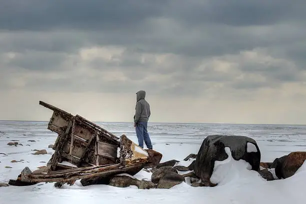 Shipwrecked teenager on a barren winter shore.