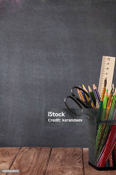 School And Office Supplies On Classroom Table Stock Photo - Download Image Now - 2015, Backgrounds, Black Color