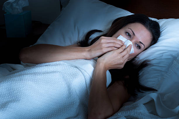 istock Sick Woman Blowing Nose in Bed 485865873
