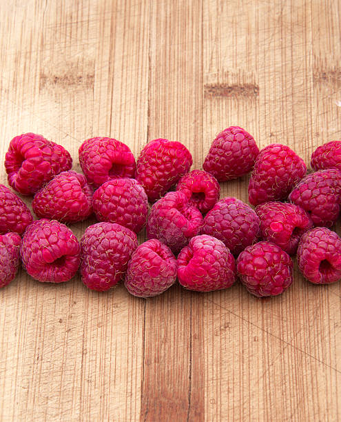 istock Ripe sweet raspberries on wood table close-up 485866746