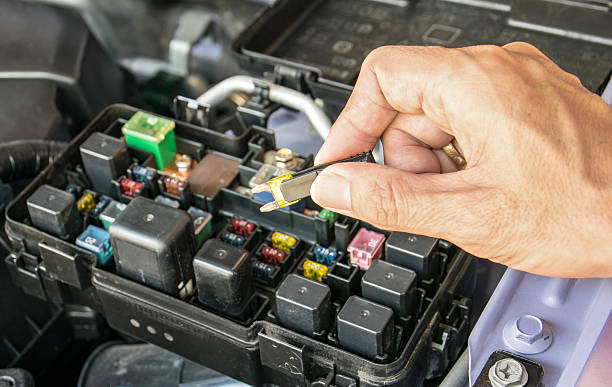 Auto mechanic checking a car fuse Auto mechanic checking a car fuse electrical fuse stock pictures, royalty-free photos & images