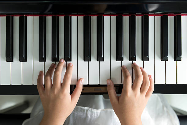 istock Little girl playing piano 485872110
