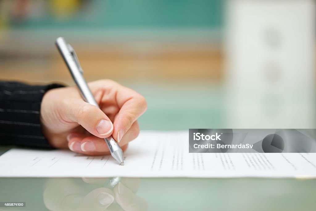 Femme remplissant document sur table en verre, eaux peu profondes offield - Photo de Écrire libre de droits