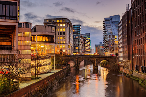 Modern apartments on both side of river Irwell passing through Manchester city center, UK.