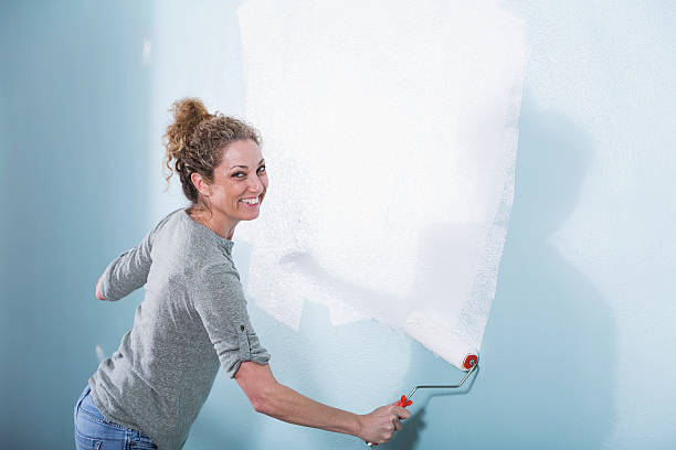 istock Woman painting wall 485878313
