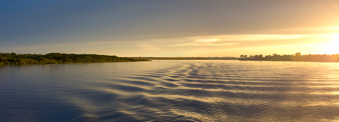 Wonderful panoramic yellow sunset on the large river Amazon. Amazonas State, Brazil