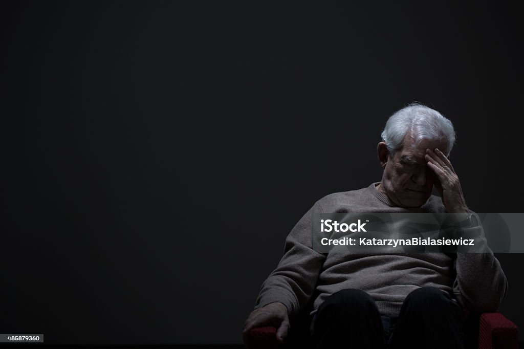 Despairing senior man Despairing senior man on a dark background Senior Adult Stock Photo
