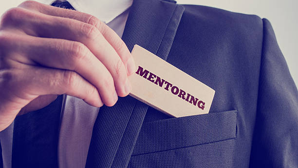 istock Businessman Holds Wooden Piece with Mentoring Text 485880986