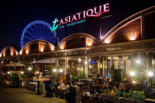 Bangkok - Asiatique The Riverfront Bangkok, Thailand - October 31, 2013: Diners having dinner around restaurants at Asiatique The Riverfront. The large-scale riverside development also features a mall, night market and a ferris wheel. thailand mall stock pictures, royalty-free photos & images