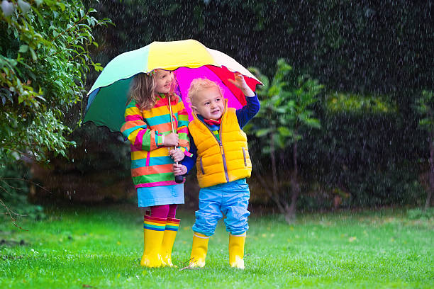 istock Kids playing in the rain under colorful umbrella 485882272