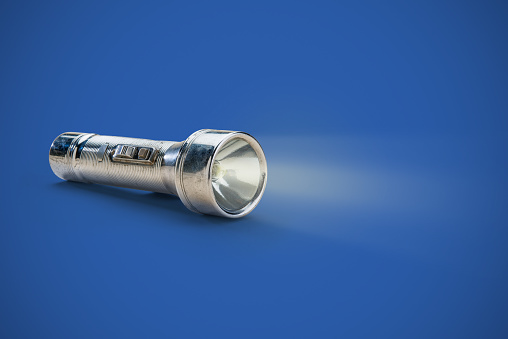 Vintage flashlight with light beam and clipping path from the 1950's