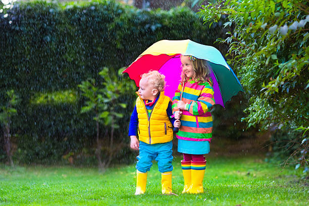 istock Kids playing in the rain under colorful umbrella 485882864