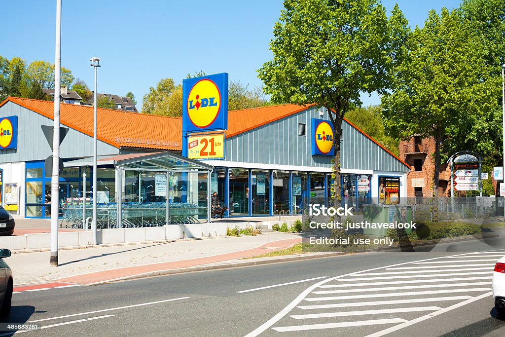 Lidl supermarket Mülheim, Germany - April 19, 2014: Capture of Lidl supermarket in Mülheim, Ruhrgebiet, View over street. A car is driving onto parking space. Outside of supermrket are people. Architecture Stock Photo