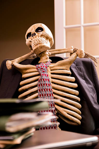 istock Working to death. Business man's skeleton with stack of files. 485883719